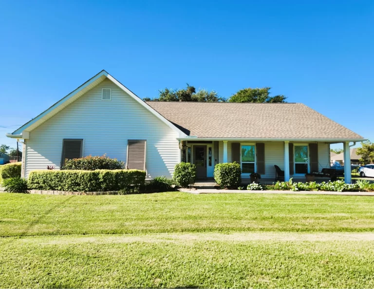 Clean, modern home exterior with well-maintained siding, manicured lawn, and colorful landscaping, showcasing outdoor features that enhance property value in Louisiana.