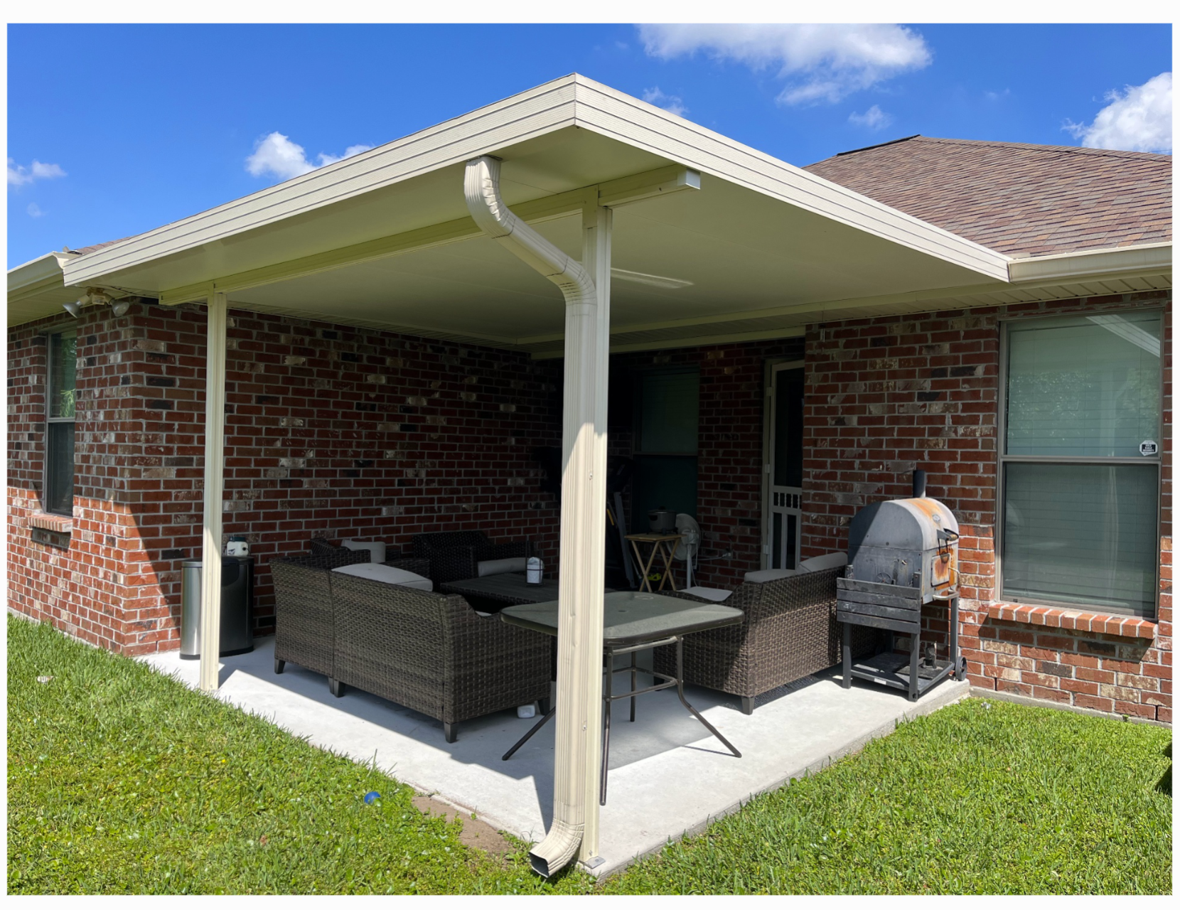 Custom aluminum patio cover installed over a backyard concrete patio at a Metairie, Louisiana home, creating shaded seating and outdoor living space.